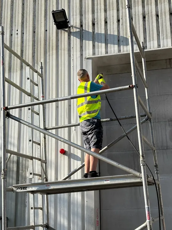 Decorator working from commercial scaffold